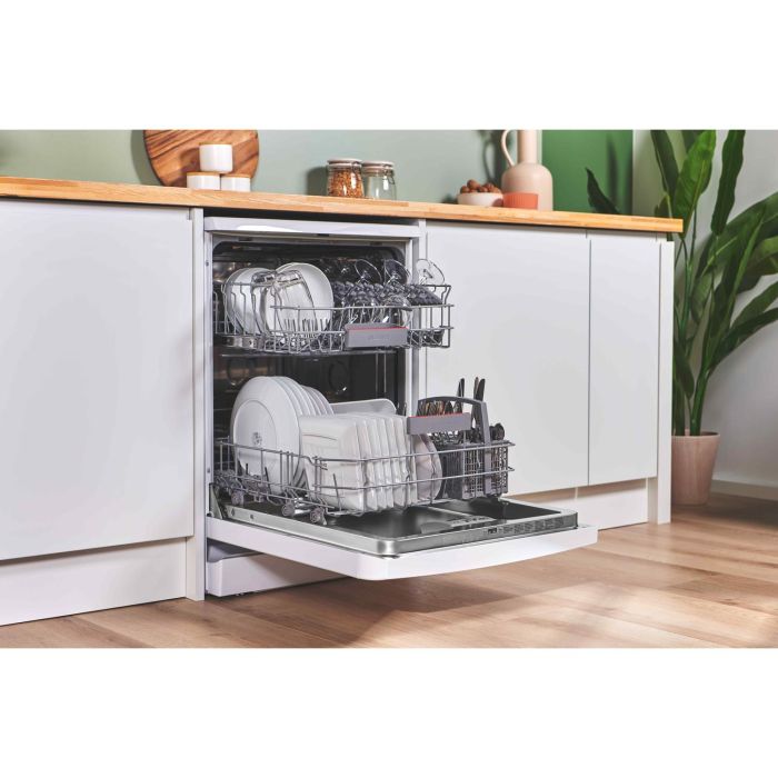 Open dishwasher loaded with clean crockery and glasses